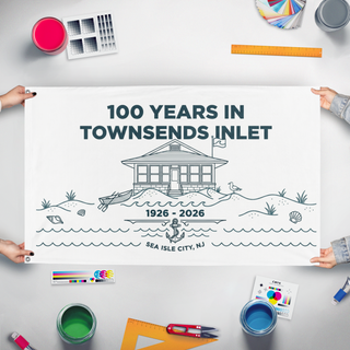 A mockup of the custom flag '100 Years in TI flag' held up on a table during print checking