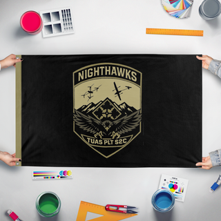 A mockup of the custom flag 'Nighthawk UAS desk flag' held up on a table during print checking