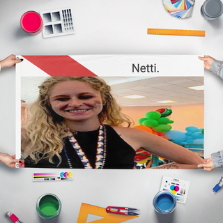 A mockup of the custom flag 'netti flag' held up on a table during print checking