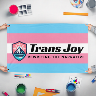A mockup of the custom flag 'TransJoy flag' held up on a table during print checking