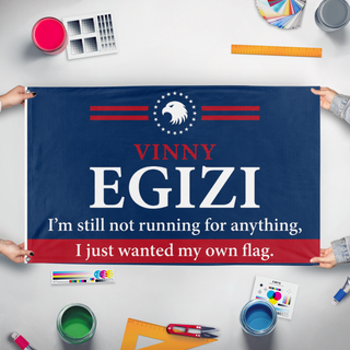 A mockup of the custom flag 'vinny egizi flag' held up on a table during print checking