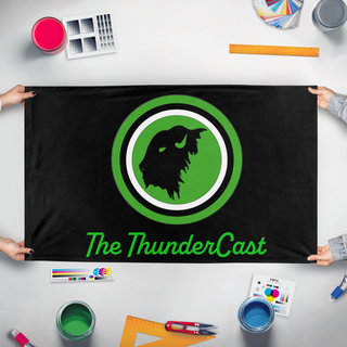A mockup of the custom flag 'ThunderCast flag' held up on a table during print checking