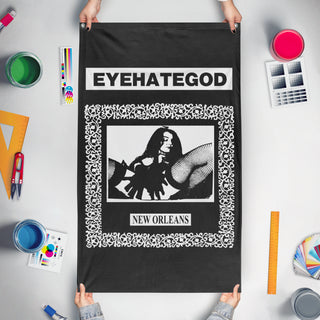 A mockup of the custom flag 'EYEHATEGOD v2 flag' held up on a table during print checking