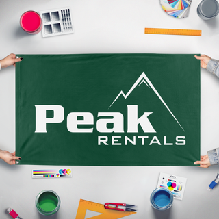 A mockup of the custom flag 'Peak Logo flag' held up on a table during print checking