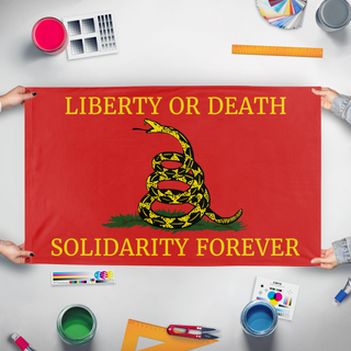 A mockup of the custom flag 'Left Libertarian Gadsden flag' held up on a table during print checking