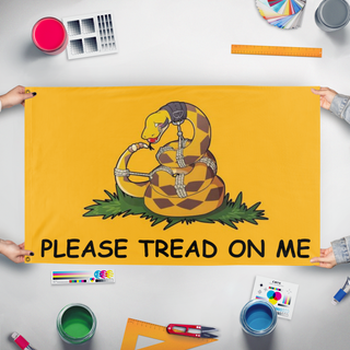 A mockup of the custom flag 'Please Tread On Me flag' held up on a table during print checking