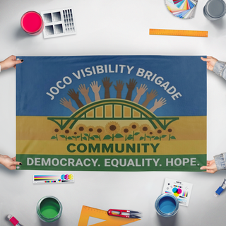 A mockup of the custom flag 'JoCoVB flag' held up on a table during print checking