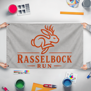 A mockup of the custom flag 'Rasselbock flag' held up on a table during print checking