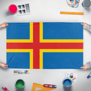 A mockup of the custom flag 'Aland Island Flag' held up on a table during print checking