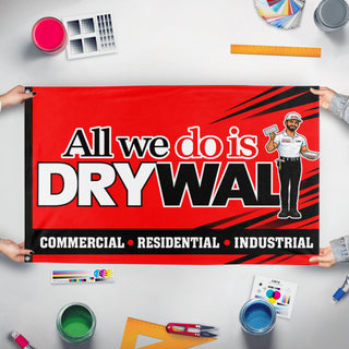 A mockup of the custom flag 'All We Do is Drywall Red flag' held up on a table during print checking