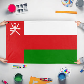 A mockup of the custom flag 'Flag of Oman' held up on a table during print checking