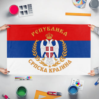 A mockup of the custom flag 'Great Seal Serbian Krajine flag' held up on a table during print checking