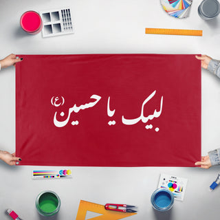 A mockup of the custom flag 'Labaik Ya Hussein Flag' held up on a table during print checking