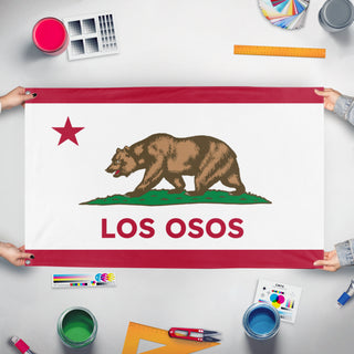 A mockup of the custom flag 'Los Osos flag' held up on a table during print checking