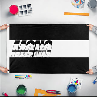 A mockup of the custom flag 'Mono flag' held up on a table during print checking