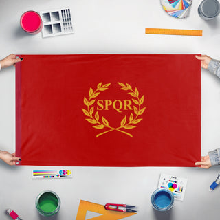 A mockup of the custom flag 'New Rome flag' held up on a table during print checking