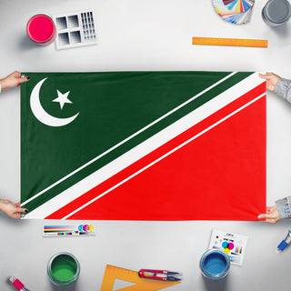 A mockup of the custom flag 'New pakistan flag redesign with tricolor' held up on a table during print checking