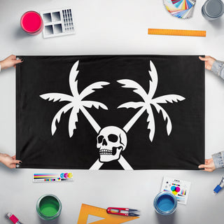 A mockup of the custom flag 'Pirate Palm Trees & Skull flag' held up on a table during print checking