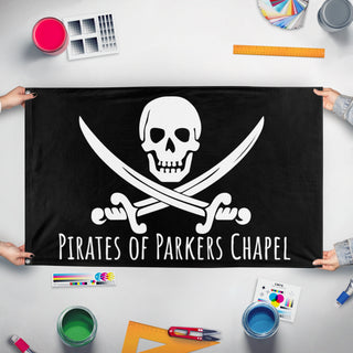 A mockup of the custom flag 'Pirates of Parkers Chapel flag' held up on a table during print checking