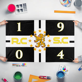 A mockup of the custom flag 'R.C.S.C flag' held up on a table during print checking