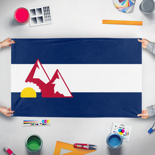 A mockup of the custom flag 'Trailform colorado flag' held up on a table during print checking