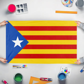 A mockup of the custom flag 'estelada flag' held up on a table during print checking