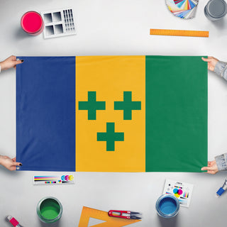 A mockup of the custom flag 'san vicente y las granadinas flag' held up on a table during print checking