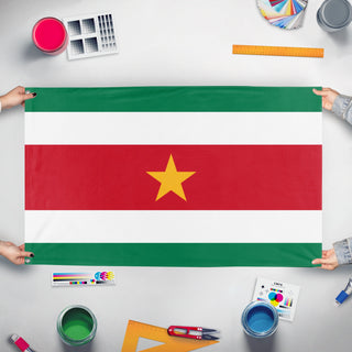 A mockup of the custom flag 'surinam flag' held up on a table during print checking