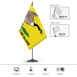A mockup of the custom flag 'Please Leave me Alone Gadsden Flag' as a desk flag and small hand waving flag